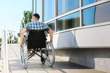 Young man in wheelchair on ramp outdoors