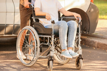 Handicapped woman and her husband near van outdoors