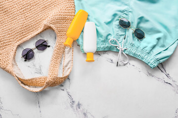 Beach bag with sunscreen cream and accessories on white background