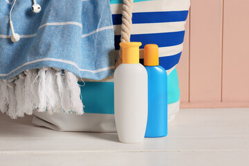 Beach bag with sunscreen cream on table
