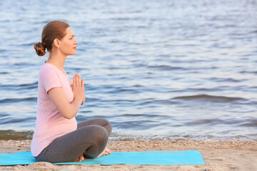 Fototapeta na wymiar Young pregnant woman practicing yoga outdoors