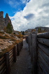 Historic World War 1 trenches and structures surrounded by rocky mountain landscapes with cloudy blue sky above. Located in The Dolomites mountains of Cinque Torri near Cortina in Italy.