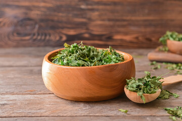 Bowl with dry parsley on table