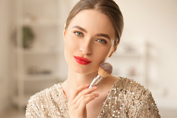 Young woman doing makeup at home