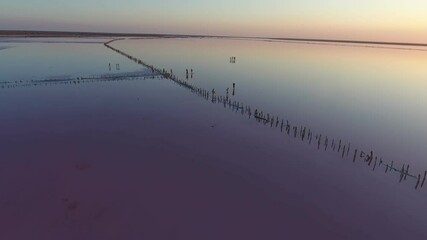 Aerial of people walking on the shallow waters of Black Sea at enigmatic sunset 