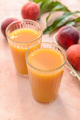 Glasses of tasty peach juice on color background