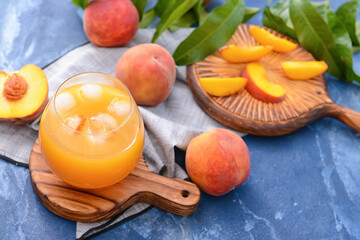 Glass of tasty peach juice on color background
