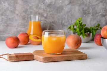 Glass of tasty peach juice on table