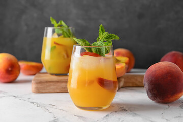 Glass of tasty peach juice on table