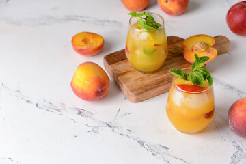 Glasses of tasty peach juice on white background