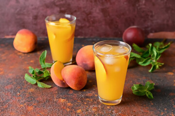 Glasses of tasty peach juice on color background