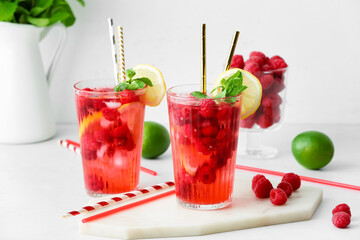 Glasses of cold raspberry tea on white background