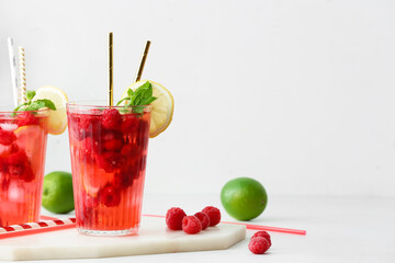 Glasses of cold raspberry tea on white background