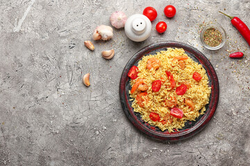 Plate with tasty pilaf on grey background