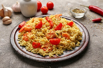 Plate with tasty pilaf on grey background