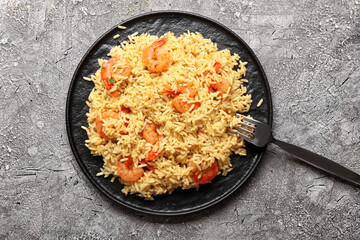 Plate with tasty pilaf on grey background