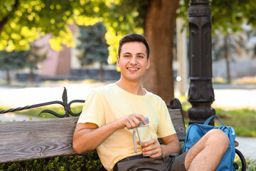 Young man with bottle of water in park