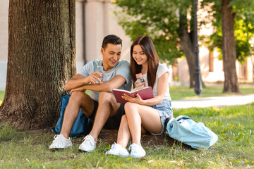 Young couple with bottles of water in park