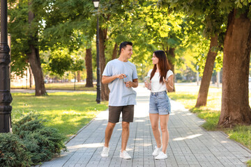Young couple with bottles of water in park