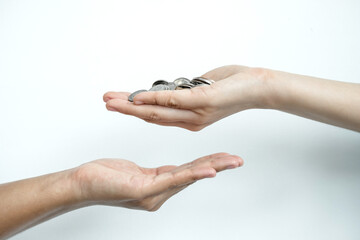 Hand holds a coin that gives the coin to the other hand. Money concept