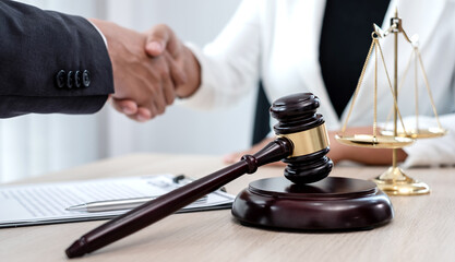 shake hand Professional male lawyers work at a law office There are scales, Scales of justice, judges gavel, and litigation documents. Concepts of law and justice