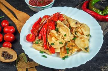 Fried dumplings with hot pepper and onion on a plate .the view from the top