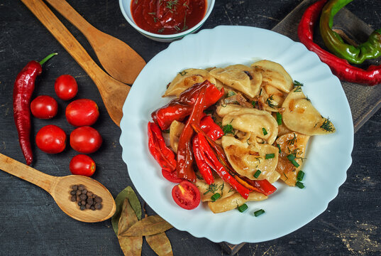 Fried Dumplings With Hot Pepper And Onion On A Plate .the View From The Top