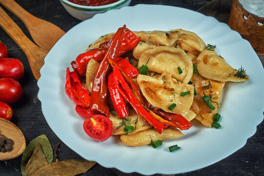 Fried Dumplings With Hot Pepper And Onion On A Plate .the View From The Top