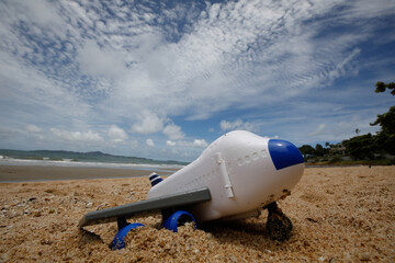 Plastic toy airplane on sandy beach