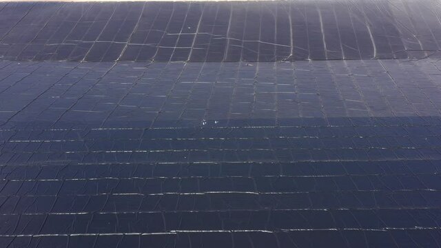 Water reservoir construction site with newly installed plastic lining sheets, Aerial view.