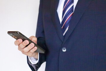 スマホを触っているスーツの男性
