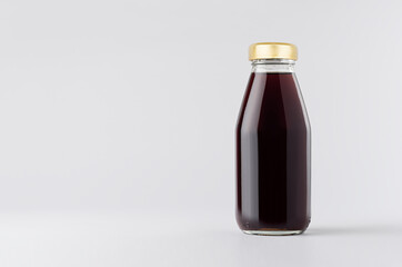 Red garnet juice in glass bottle with gold cap mock up on white background with copy space, template for packaging, advertising, design product, branding.