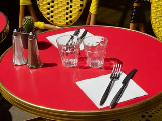 Cozy cafes on the streets of Paris sunlit. Red tables, yellow chairs of Paris restaurants. Family holidays in Europe - summer, spring. A cozy place for business negotiations, discussion, conversations