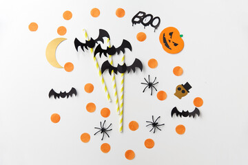 holidays and decorations concept - halloween party props and paper straws over white background