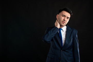 Portrait of business man wearing blue business suit and tie gesturing neck ache