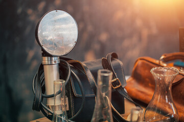 Old fashioned camera with flash unit and leather bag on the countertop at sunday flea market.Vintage furniture in antique bazaar