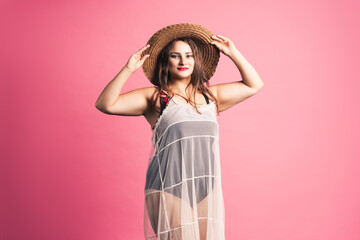Plus size fashion model in black one-piece swimsuit, fat woman in lingerie on pink background