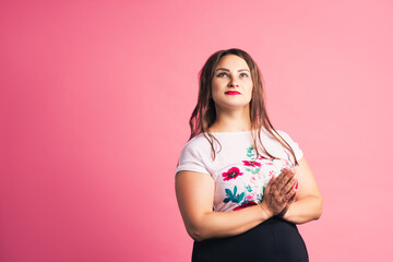 Pensive plus size model on pink background