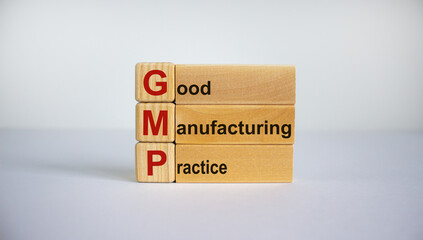 Concept words 'GMP, good manufacturing practice' on cubes and blocks on a beautiful white background. Business concept. Copy space.