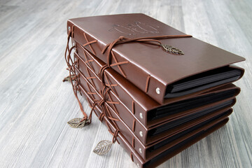 Vintage brown leather photo scrapbook albums on a grey wood background