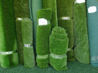 collection of rolls of artificial turf hold together with plastic tape