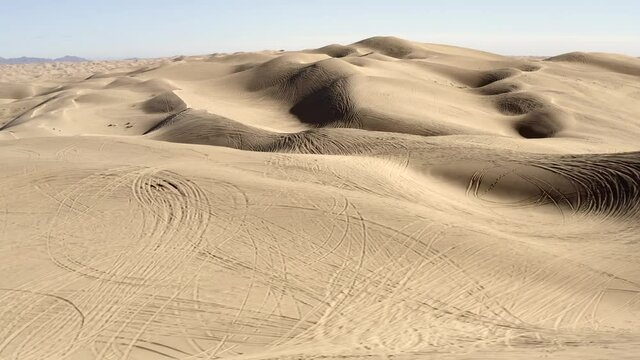 Tire tracks from all terrain vehicles ATVs on desert sand dunes, aerial view