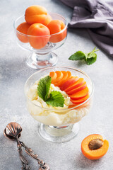 Dessert of sweet cottage cheese and fresh apricot berries with mint leaves.