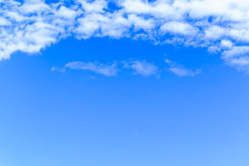 Beautiful fluffy white clouds float in the blue sky on a nice day in summer. Blue is the beautiful color of nature.