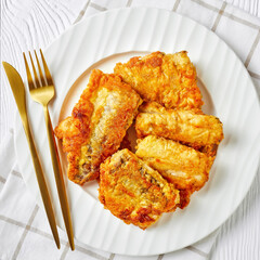 Beer-battered pan-fried hake fish fillet, close-up