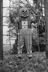  Halloween. Creepy clown.Evil clown on the playground in the autumn park. Black and white photo.Autumn holidays.Horror and fear.Carnival holidays in October