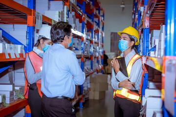 Fototapeta na wymiar Industry manager, engineer and worker under discussion about production at factory plantation. They wearing safety uniform hard hat ,face mask to protect virus in new normal concept.