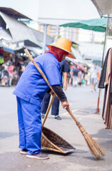 Municipal officials are sweeping the streets inside Chatuchak Market, Bangkok.