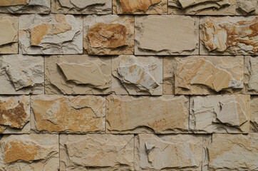 Stone tiles on the wall. The wall is made of ceramic, granite tiles. The structure of the stone.