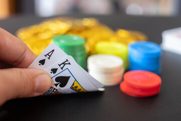 The Casino table with cards showing black jack on hand and blurred casino chips and Gold coin  in the background